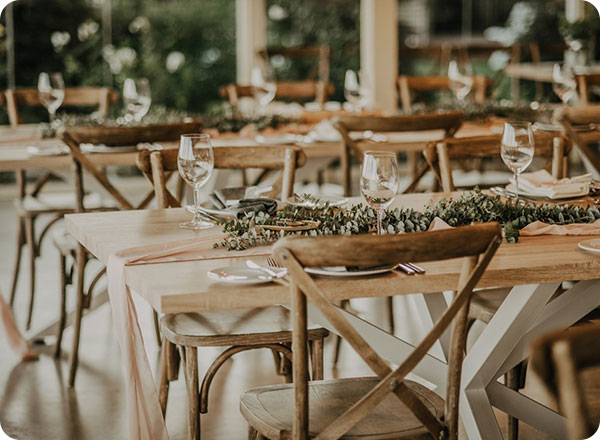 Photo shows wooden tables setup for a wedding