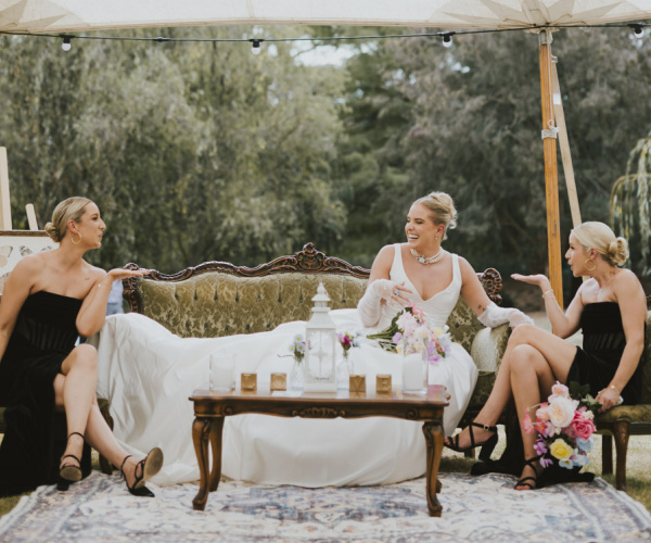 Laughing bride lounging on a vintage couch at her Karrawingi Park wedding