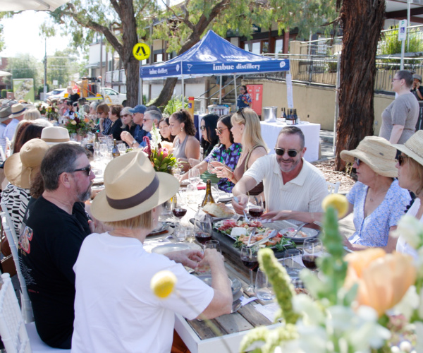 Happy guests enjoying lunch outside in the sunshine